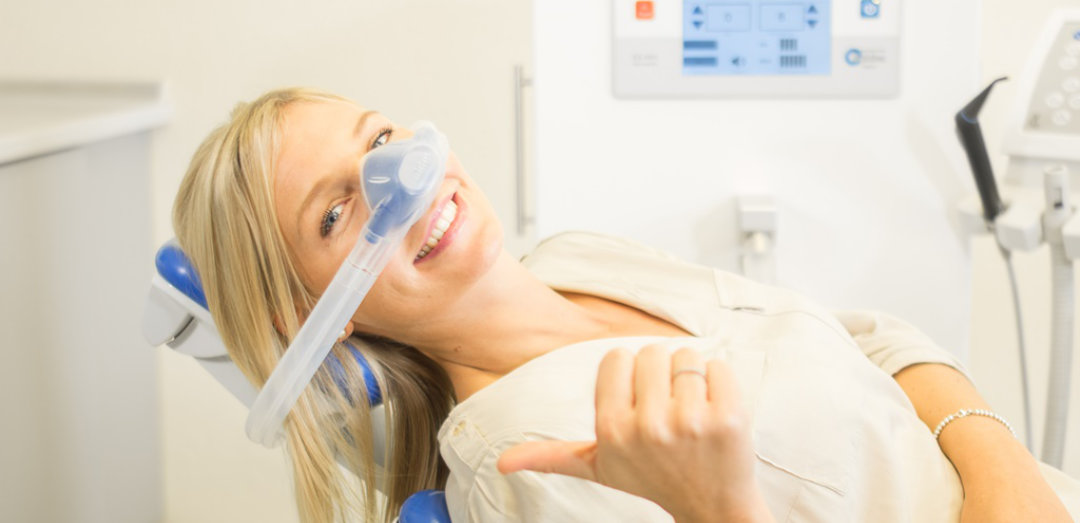 lächelnde Frau mit Atemmaske beim Zahnarzt